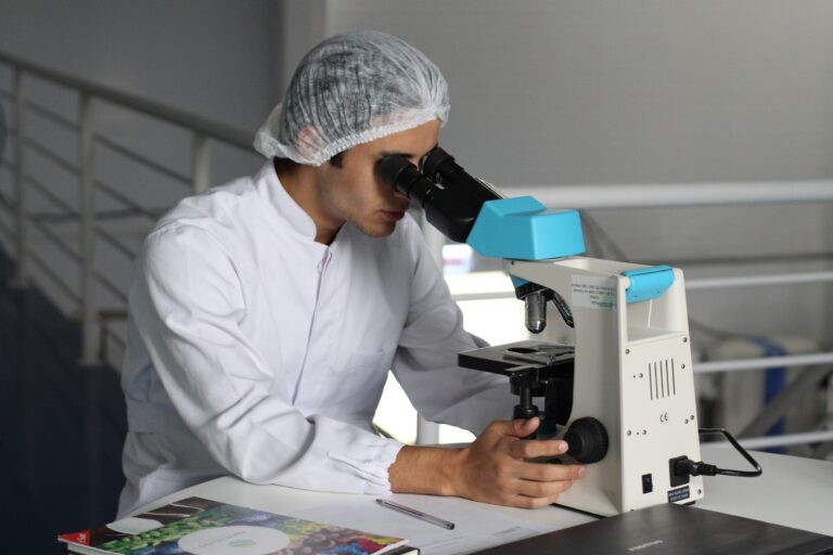 image of male researcher looking into a microscope