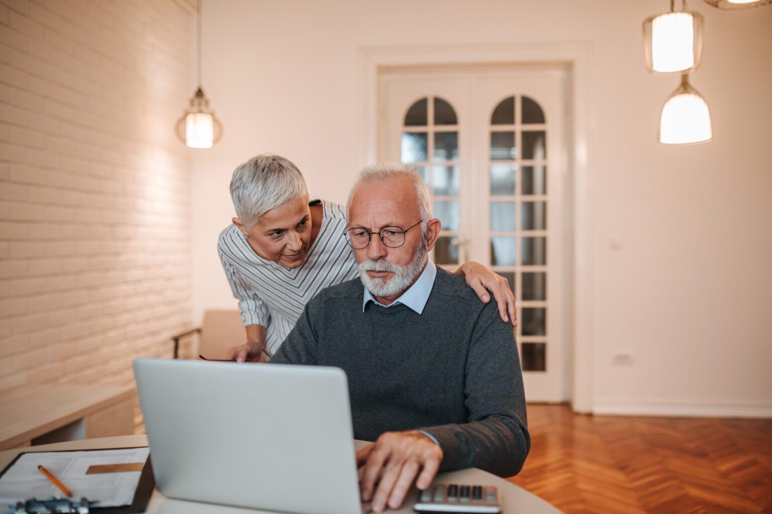 Worried mature couple looking at a computer screen