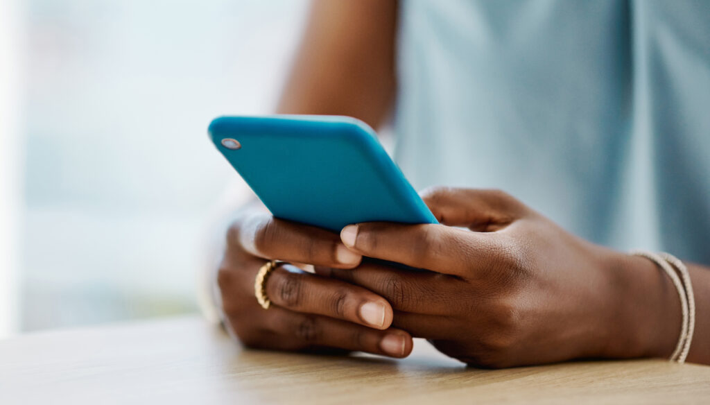 A woman holding a mobile phone in her hands.