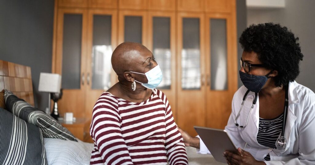 Home health care worker speaking with a cancer patient.